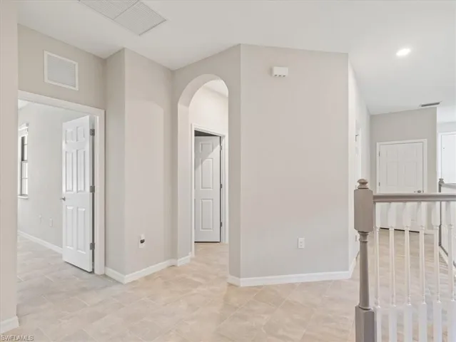 Corridor featuring light tile flooring