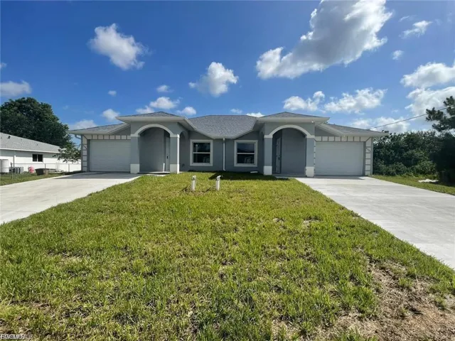Single story home with a garage, a front yard, and driveway