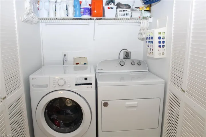 Clothes washing area featuring washing machine and dryer