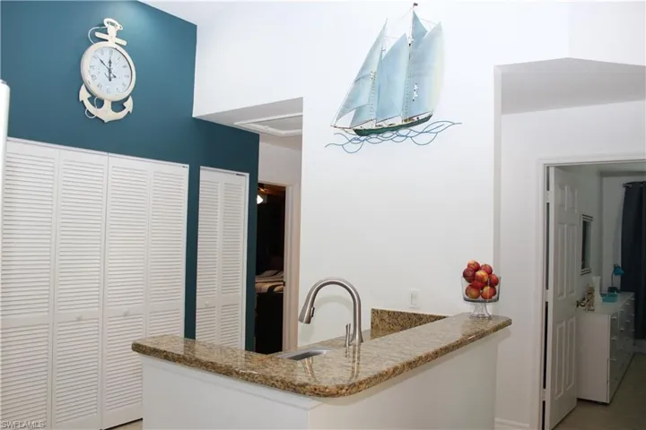 Kitchen with kitchen peninsula, sink, and light tile patterned flooring