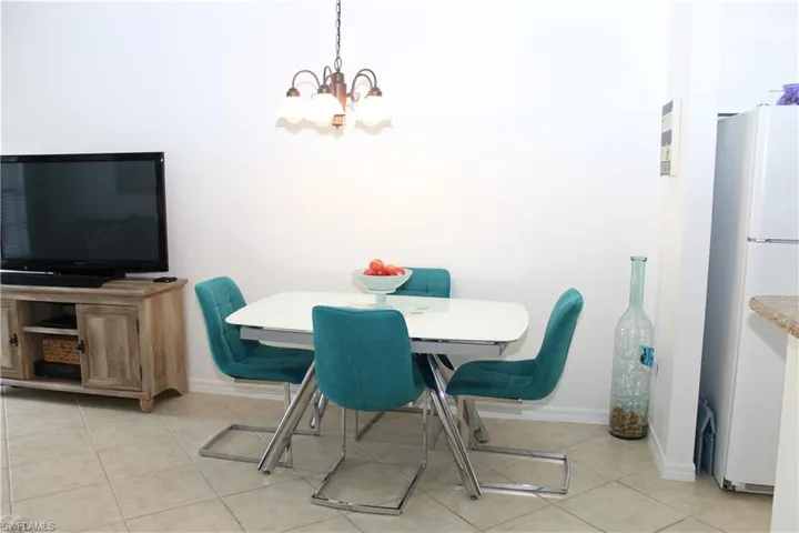 Tiled dining space featuring a chandelier