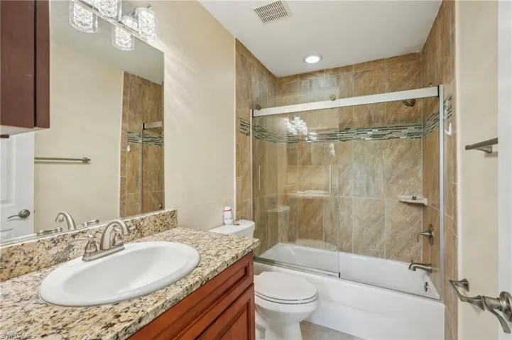 Bathroom with vanity and shower / bath combination with glass door