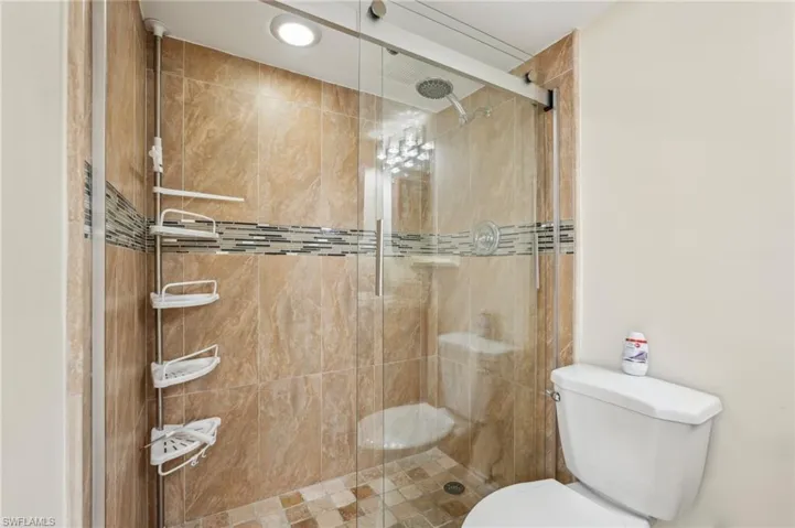 Bathroom featuring toilet and a shower stall