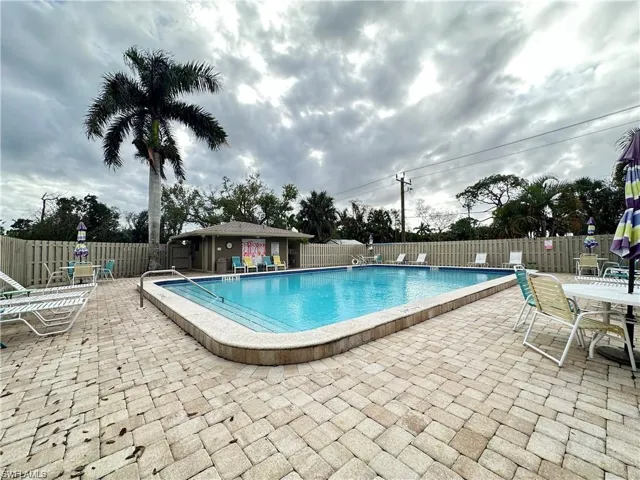 Community pool featuring a patio and outdoor dining area
