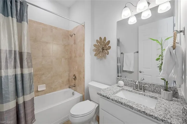 Full bathroom featuring vanity, toilet, and shower / bath combo with shower curtain