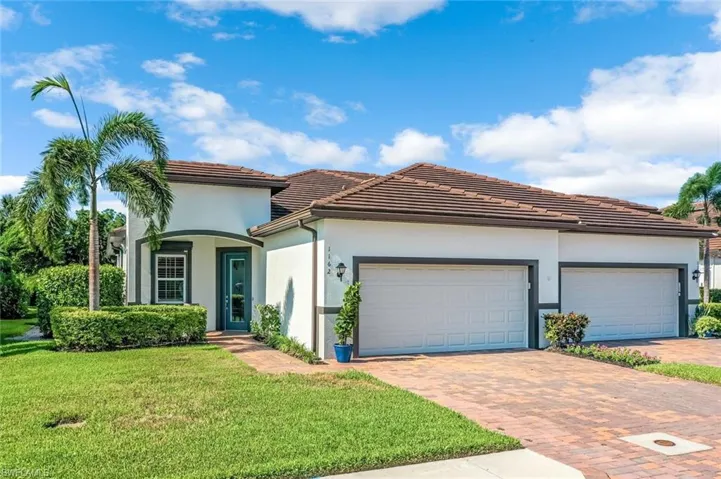 View of front of property with a front yard and a garage