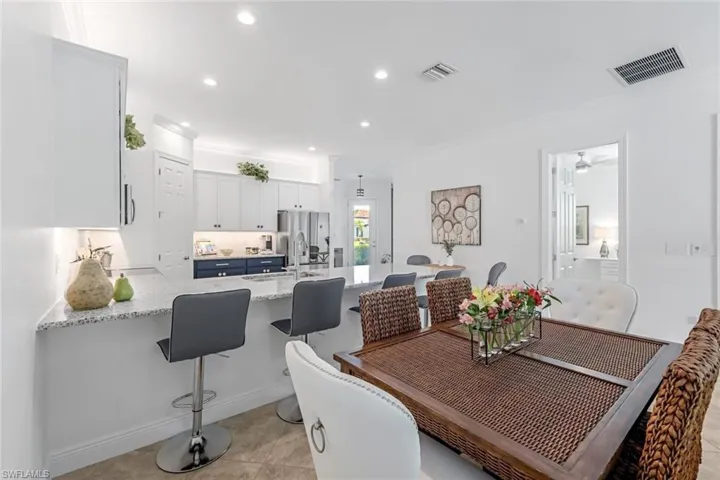 Tiled dining room with crown molding, sink, and ceiling fan