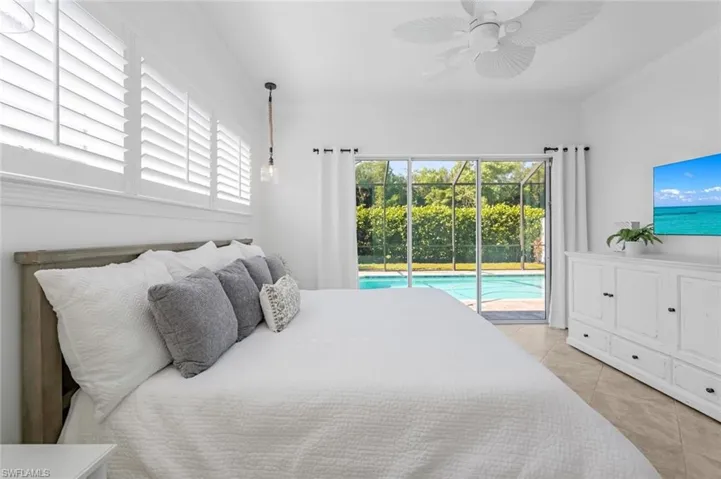 Tiled bedroom with ceiling fan, access to exterior, and crown molding