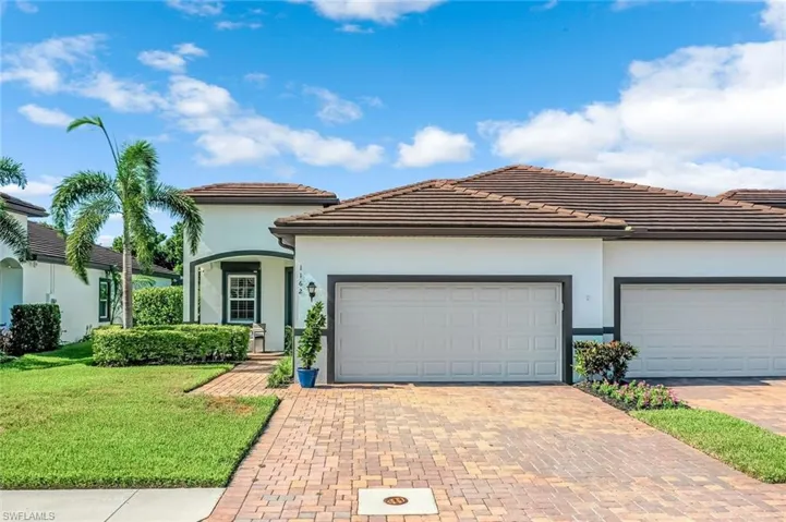 View of front of house with a garage and a front lawn