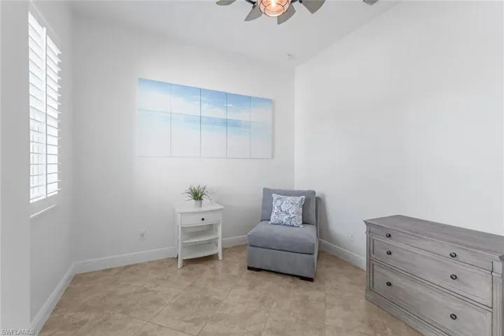 Living area with ceiling fan and light tile floors