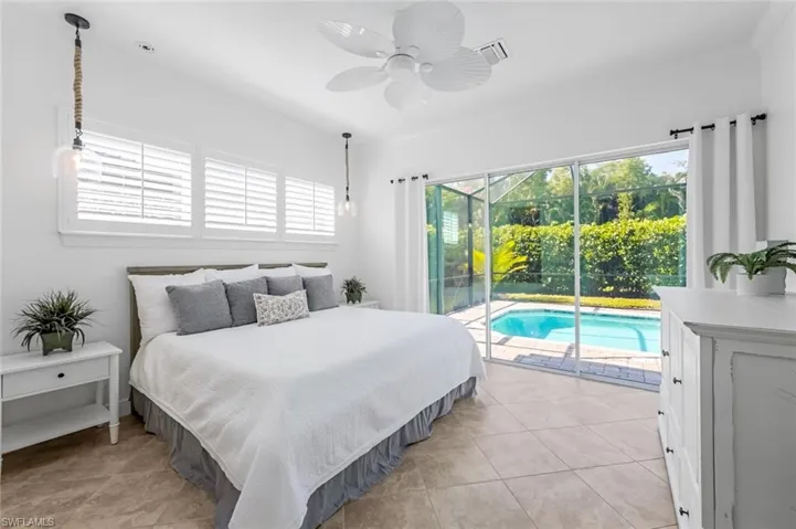 Tiled bedroom featuring ceiling fan and access to outside