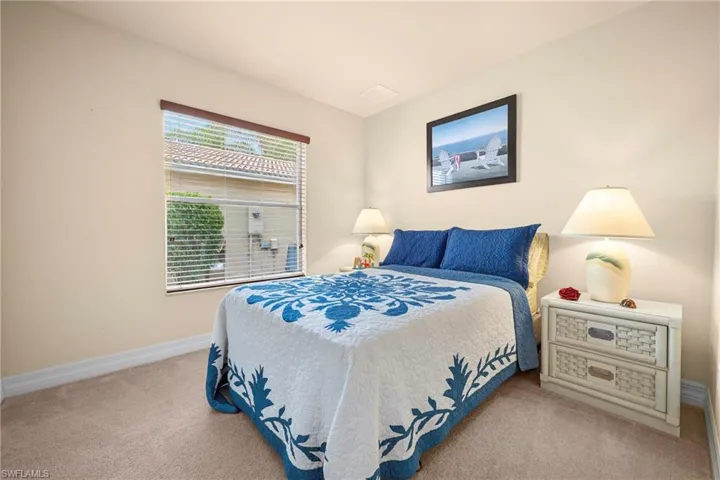 Light-filled room featuring neutral wall tones, plush carpet flooring, a window with blinds and a wood cornice, and a built-in recessed ceiling light fixture