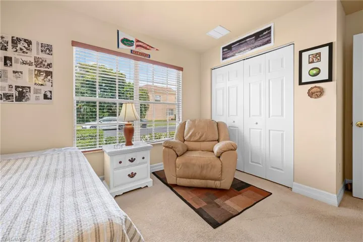 Room featuring light beige carpet flooring and a large window with horizontal blinds