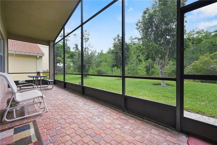 Screened patio featuring paver flooring and direct access to a grassy outdoor area