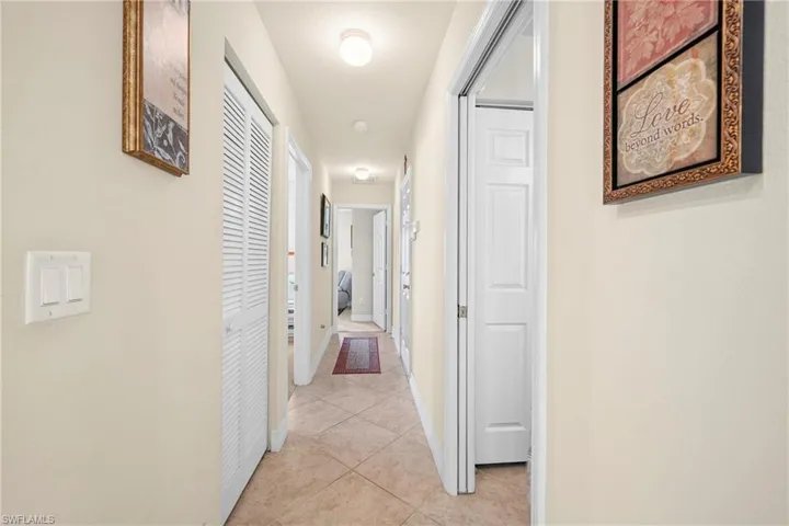 Hallway with neutral wall tones and tile flooring