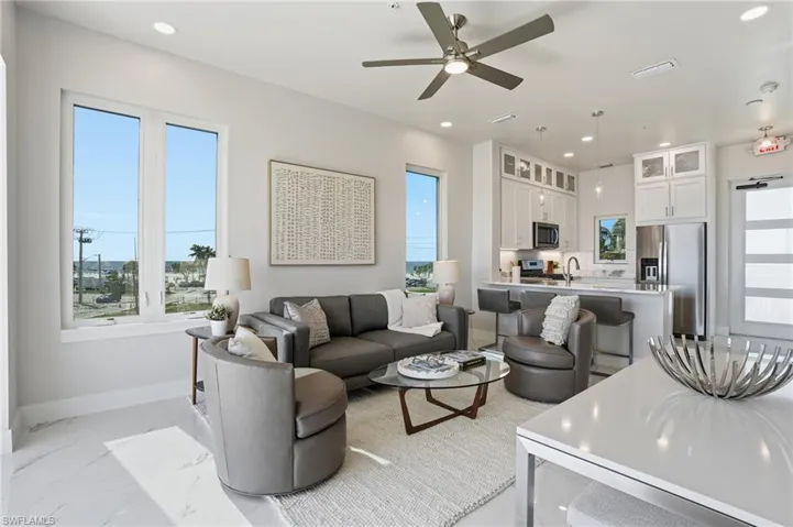 Living area with recessed lighting, light marble finish floors, and ceiling fan - Virtually Edited Image