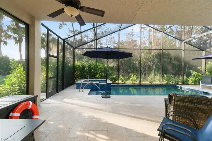 Screened Pool and Spa with travertine flooring, ample seating/sunning area. Only lush landscaping and protected area (plus sky) is beyond!