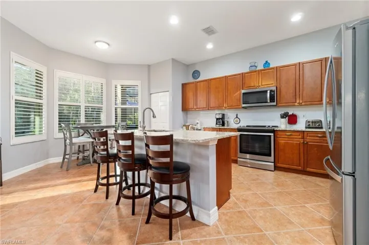 Stainless appliances, serving bar with breakfast area overlooking  the pool.