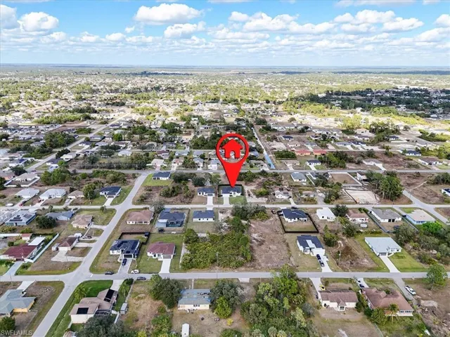 Aerial view of property and surrounding area with nearby suburban area