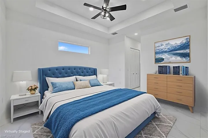 Bedroom with a raised ceiling, a closet, a ceiling fan, recessed lighting, and marble finish floors