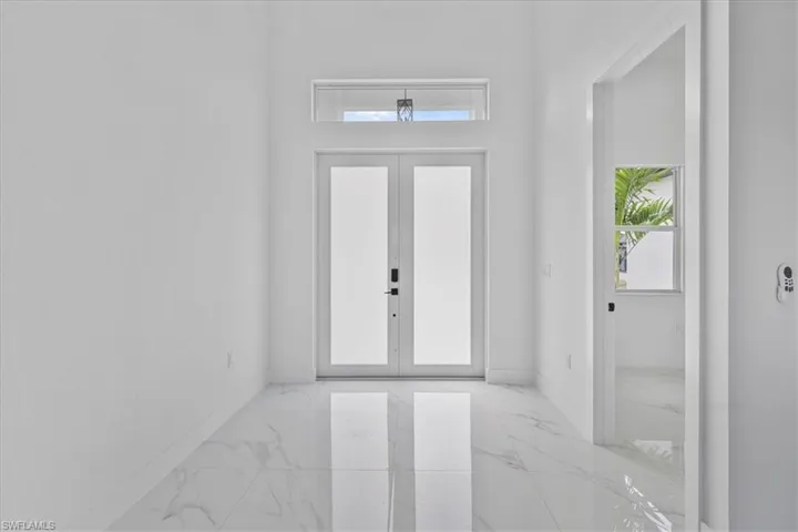 Entryway featuring french doors and light marble finish flooring