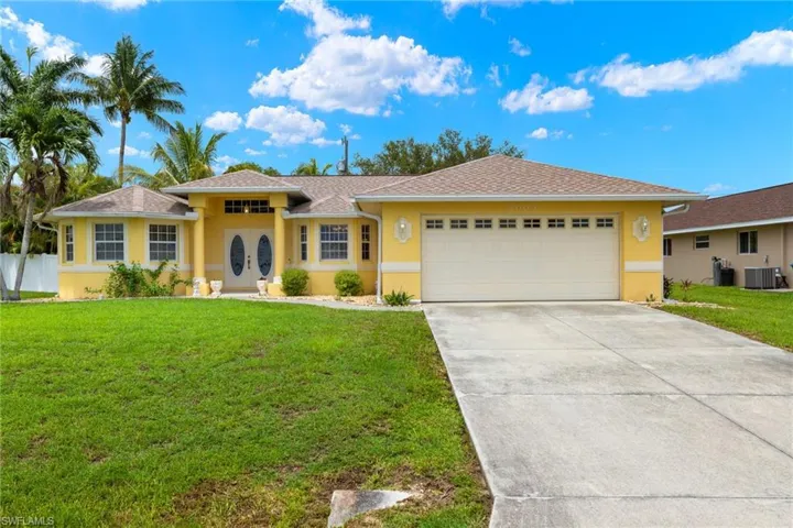 Ranch-style house with a garage, central AC, and a front lawn
