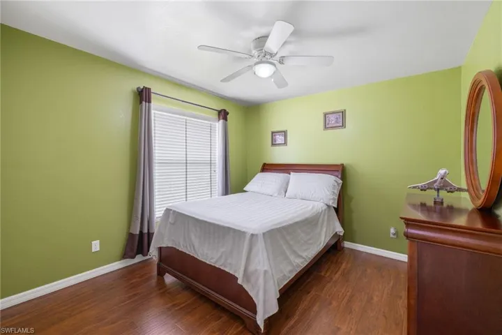 Bedroom featuring ceiling fan and dark wood-type flooring
