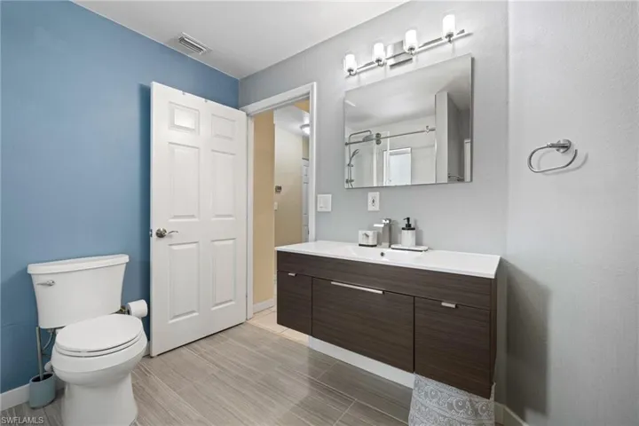 Bathroom featuring vanity, toilet, and tile patterned floors