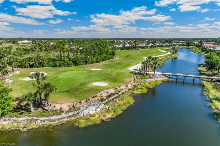 The property is situated alongside a golf course featuring green fairways, sand traps, and palm trees
