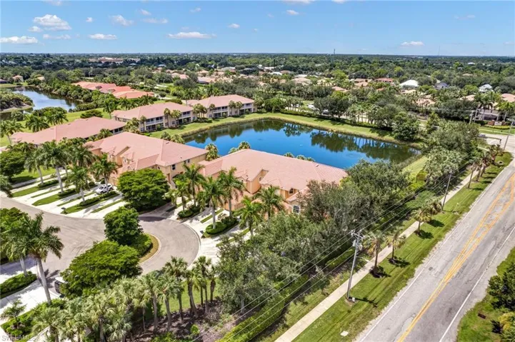 Lush landscaping, a tranquil pond, and mature palm trees define the property's surroundings
