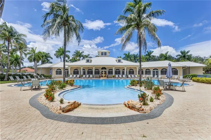 Expansive outdoor pool with integrated spa and surrounding paver deck