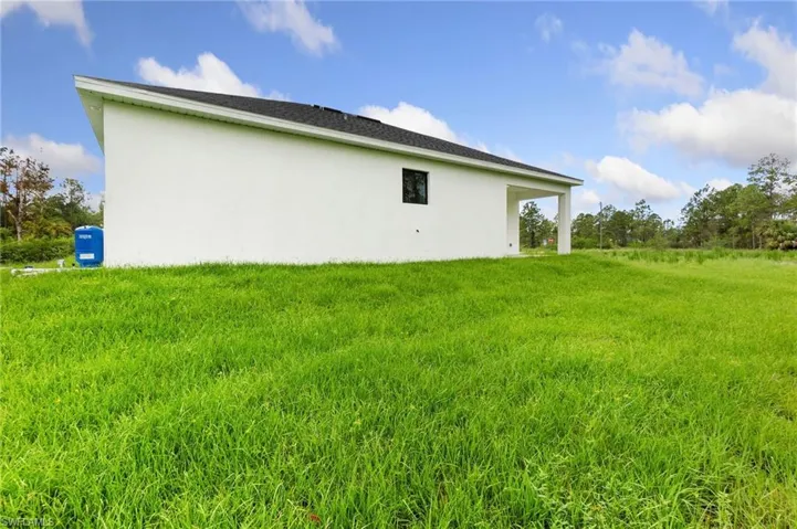 View of side of home featuring stucco siding and a yard