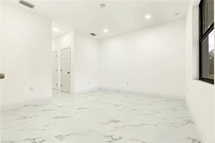Unfurnished room with recessed lighting and light marble finish floors