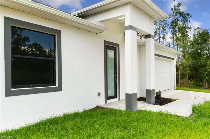 Doorway to property featuring stucco siding and an attached garage
