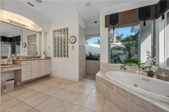 Primary Bath featuring separate water closet (with bidet), extra large closet, linen closet, double sinks, jetted tub and private shower overlooking hidden garden.