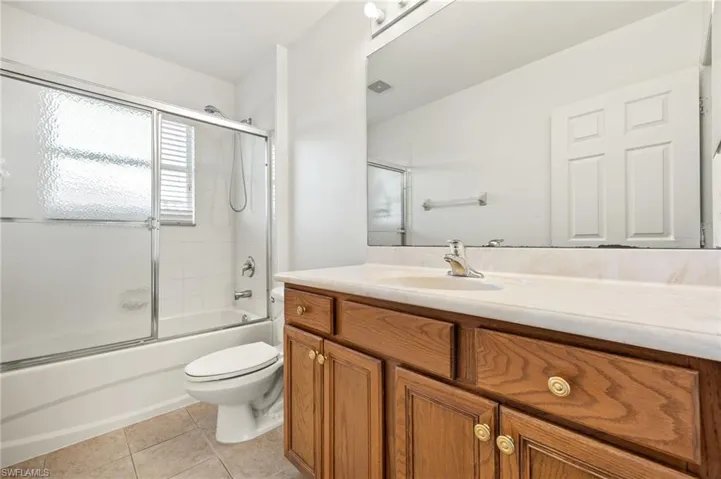 Full bathroom with vanity, combined bath / shower with glass door, and light tile patterned flooring