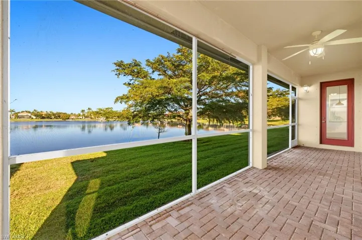 Unfurnished sunroom featuring a ceiling fan and a water view