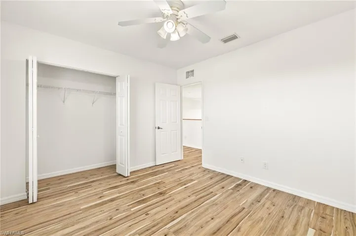 Unfurnished bedroom with ceiling fan, light wood-style floors, and a closet