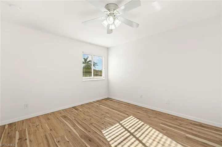 Empty room with light wood-style floors and a ceiling fan