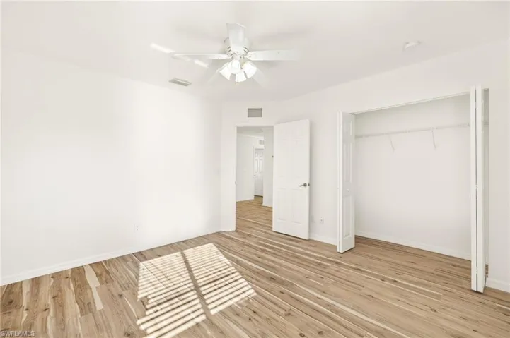 Unfurnished bedroom with a ceiling fan, light wood-style floors, and a closet