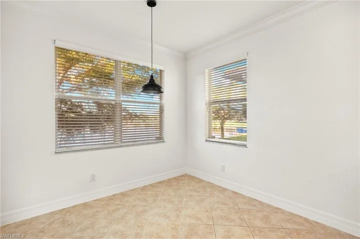 Empty room featuring crown molding and light tile patterned flooring