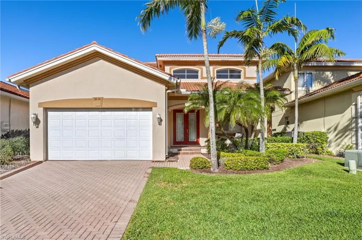 Mediterranean / spanish-style home featuring stucco siding, decorative driveway, an attached garage, and a front yard