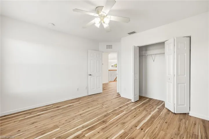 Unfurnished bedroom featuring light wood-type flooring, a ceiling fan, and a closet