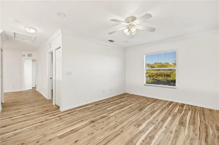 Unfurnished room featuring ornamental molding, light wood finished floors, and a ceiling fan