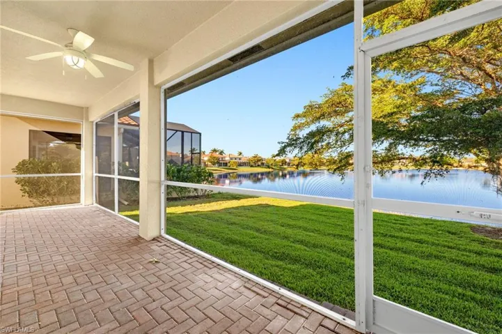 Unfurnished sunroom featuring a water view, ceiling fan, and a patio area