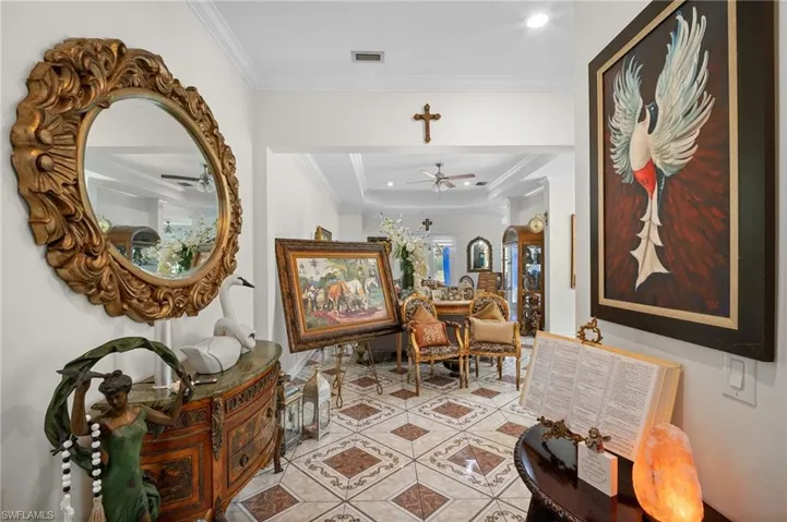 Corridor featuring crown molding, a tray ceiling, tile patterned flooring, recessed lighting, and arched walkways