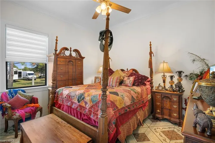 Tiled bedroom with crown molding and a ceiling fan