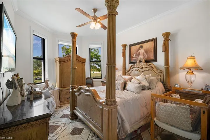 Bedroom with ornamental molding, a ceiling fan, and light tile patterned flooring