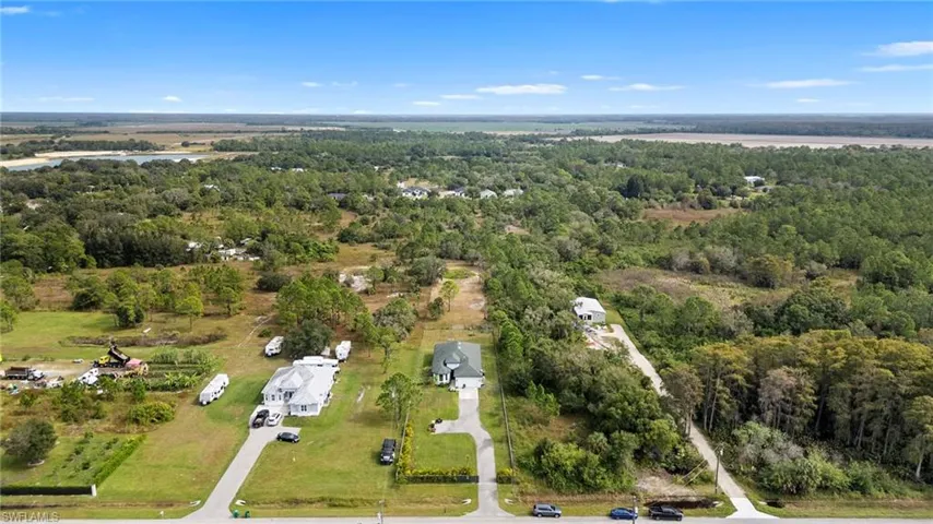 Aerial overview of property's location with a forest and a large body of water