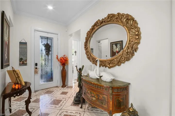 Entryway featuring ornamental molding and tile patterned floors